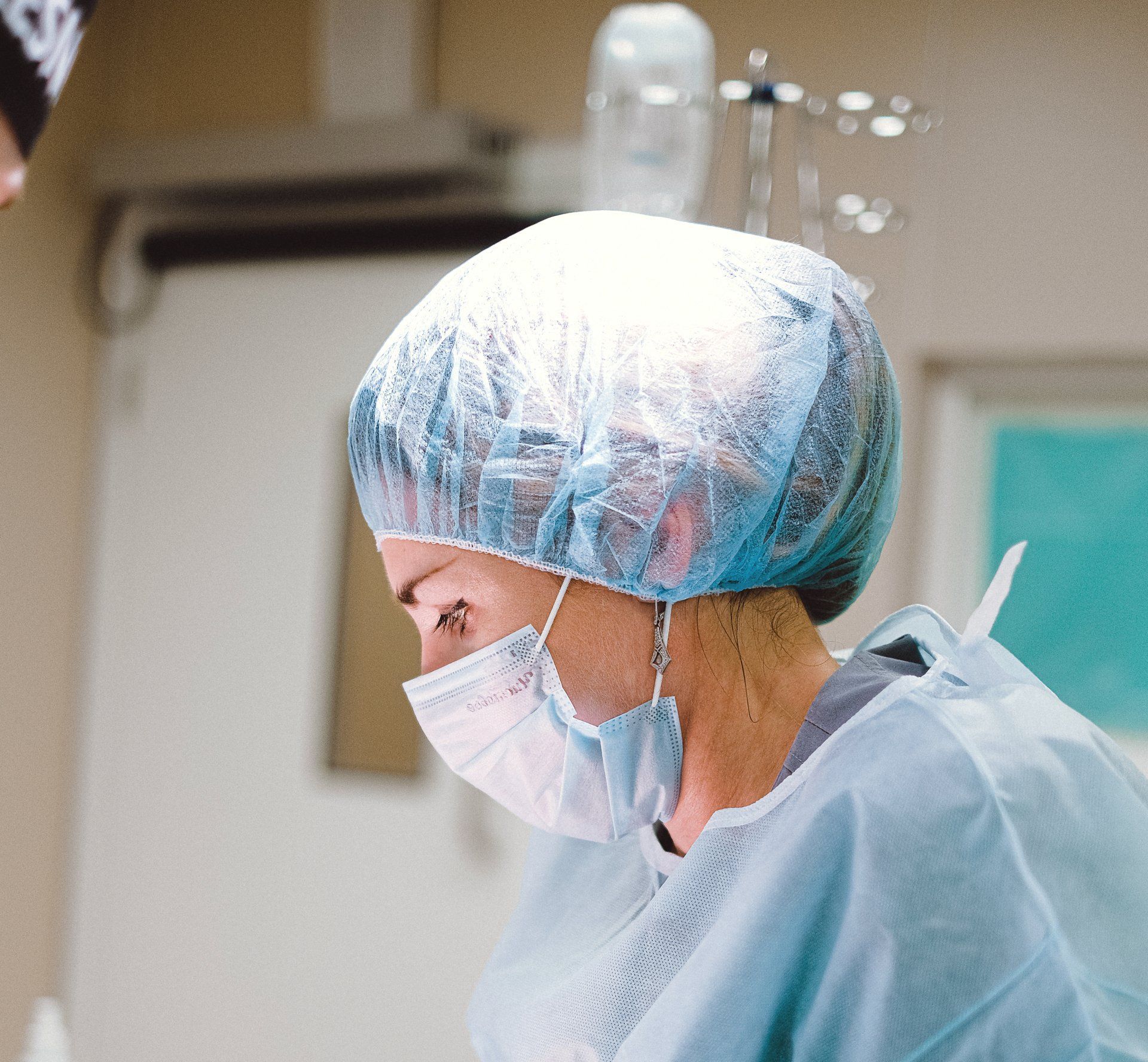 A female surgeon wearing a mask and gown