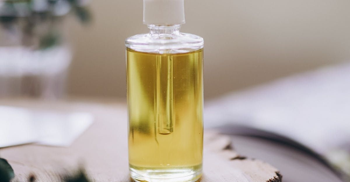 A bottle of essential oil is sitting on a wooden table.