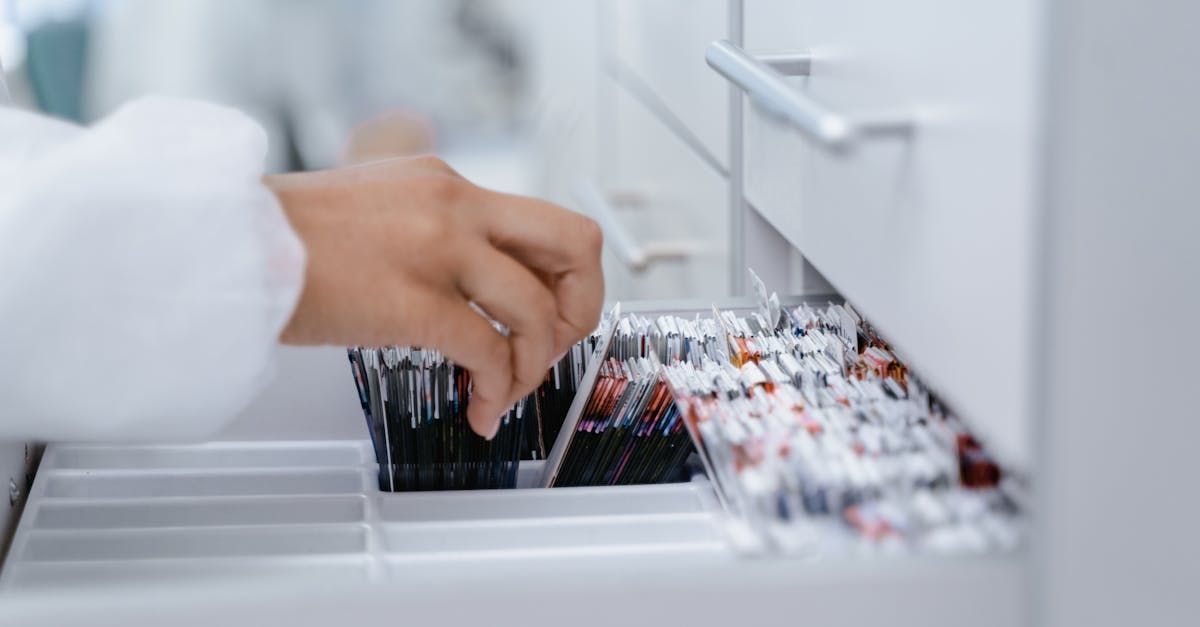 A person is taking a pill out of a drawer.