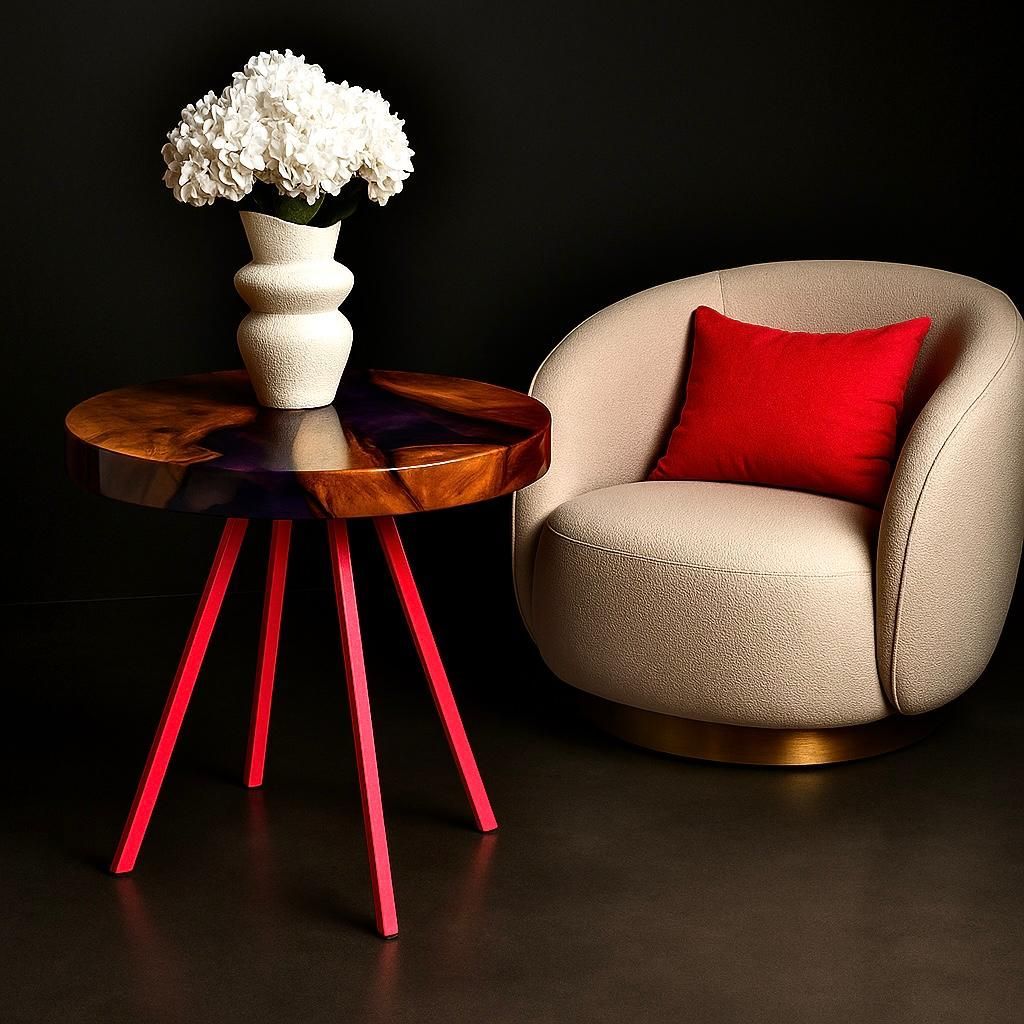 Ronde houten tafel met rode poten, witte vaas met bloemen en beige fauteuil met rood kussen.