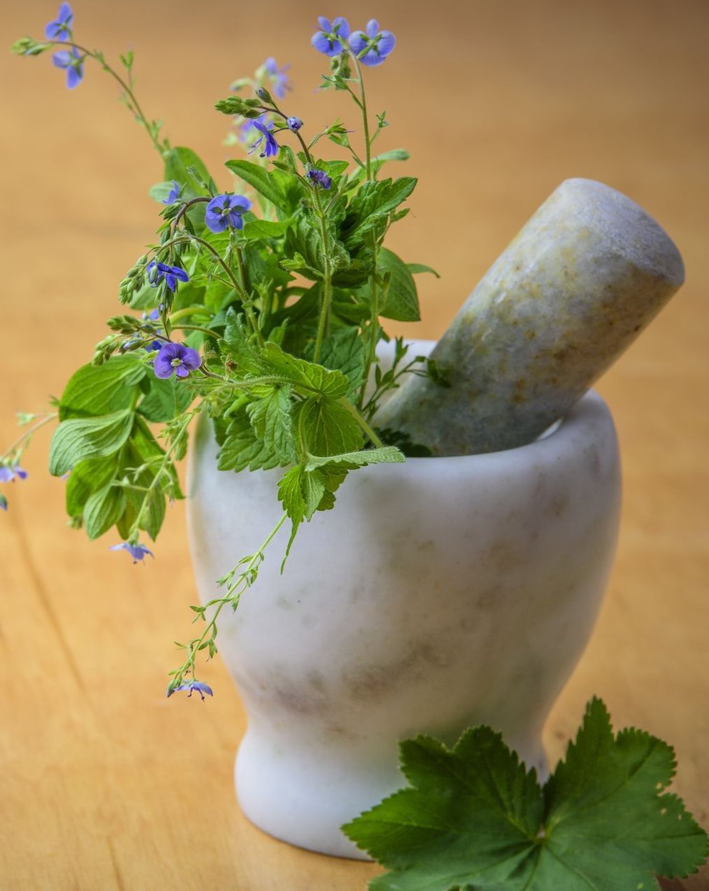 A mortar and pestle with flowers in it