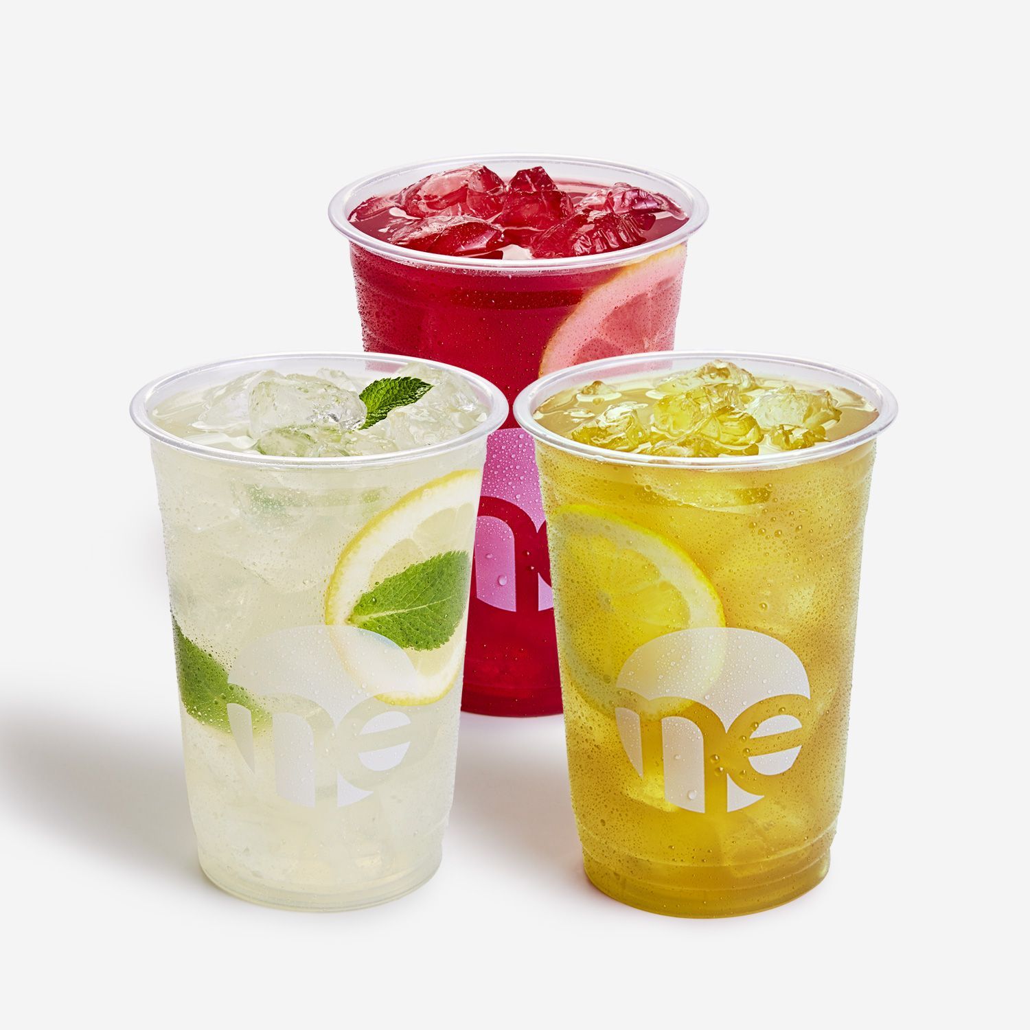 Three cups of different flavored drinks are sitting next to each other on a table.