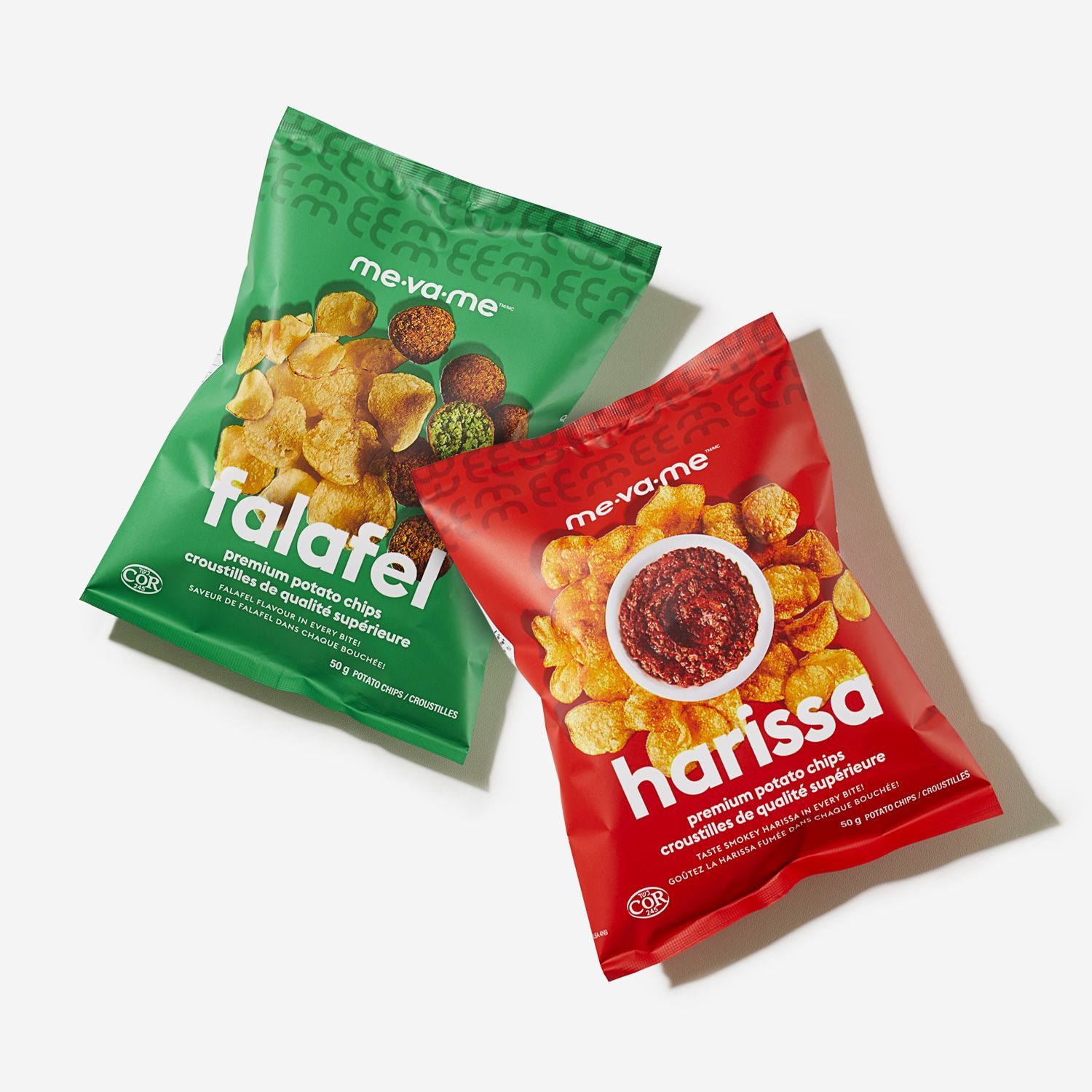 Two bags of falafel and harissa chips are sitting next to each other on a table.