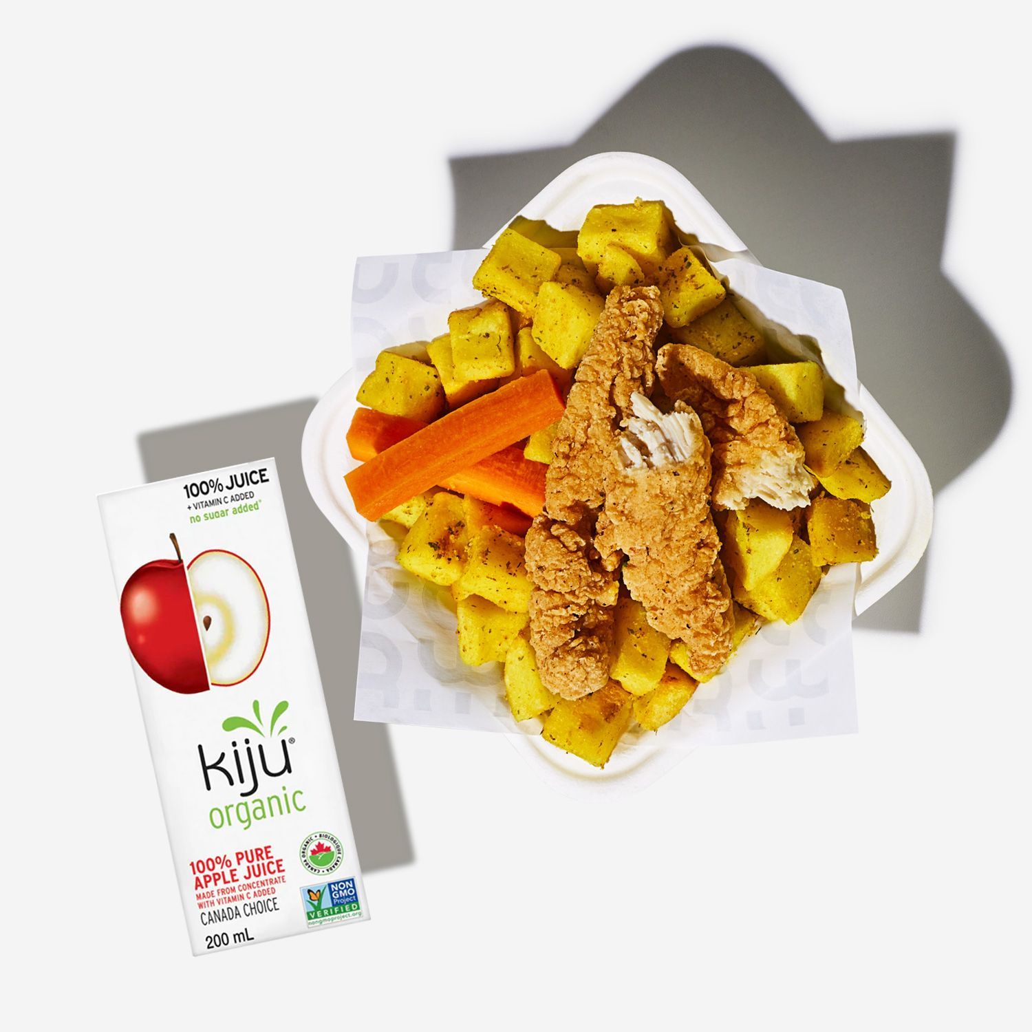 A box of kiju organic apple juice next to a plate of food