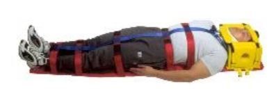 Un hombre está tendido en una camilla con un casco en la cabeza.