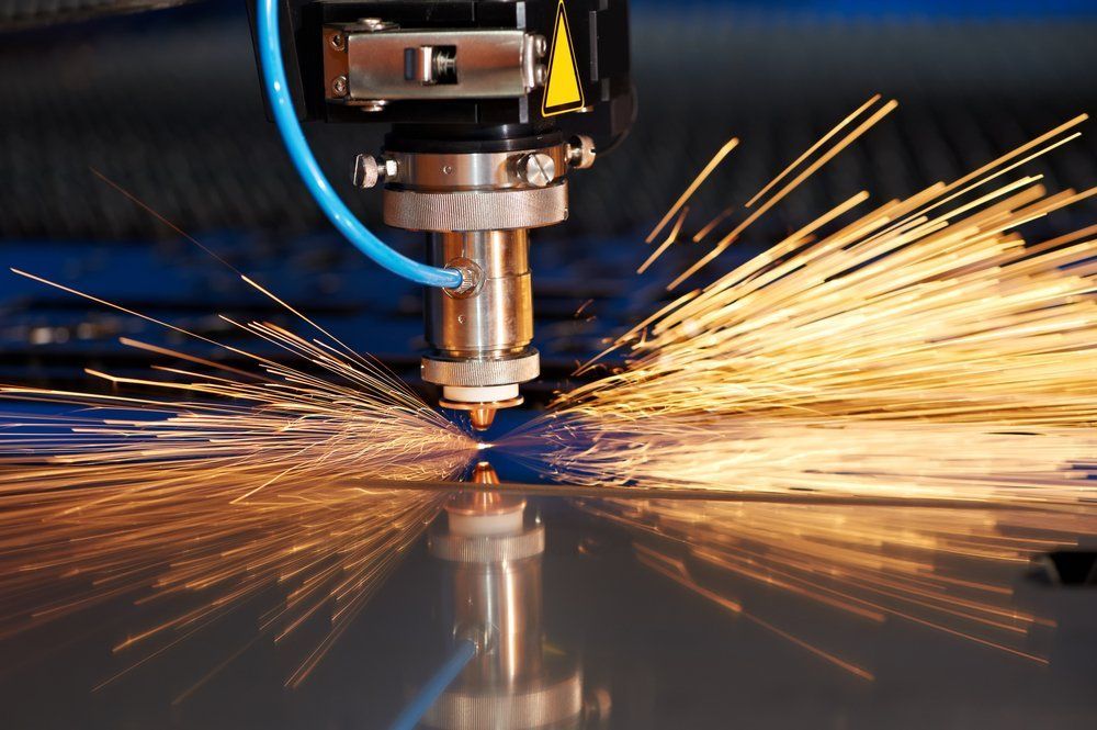 A Machine Is Cutting a Piece of Metal with Sparks Coming out Of It — Mayric Engineering in Taree, NSW