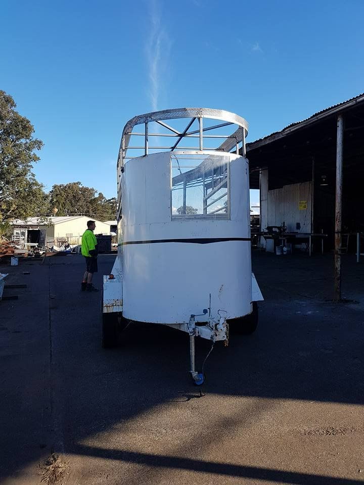 A White Trailer Is Parked in A Parking Lot in Front of A Building — Mayric Engineering in Wingham, NSW