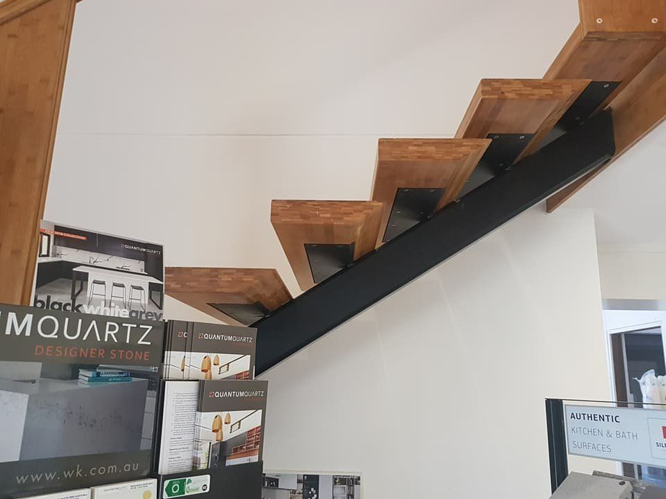 A Staircase with Wooden Steps and A Metal Railing in A Store — Mayric Engineering in Taree, NSW