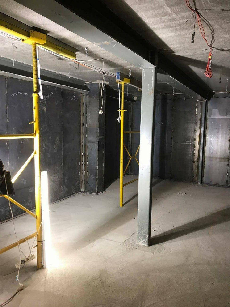 An Empty Room with Scaffolding and A Light on The Floor — Mayric Engineering in Hallidays Point, NSW