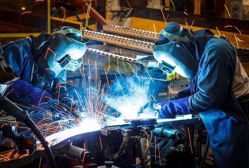 Two Men Are Welding a Piece of Metal in a Factory — Mayric Engineering in Taree, NSW