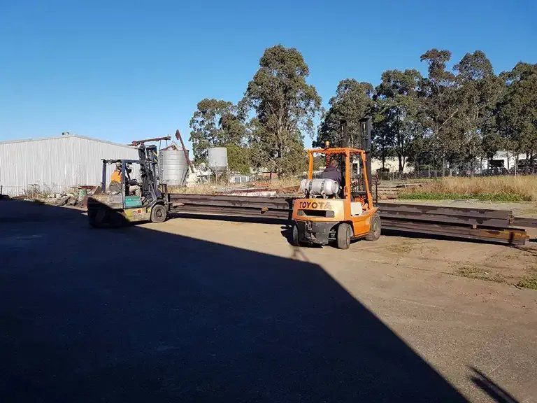 A Forklift Is Carrying a Large Piece of Metal in A Yard — Mayric Engineering in Old Bar, NSW