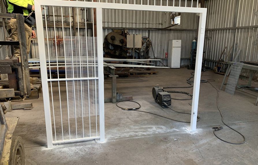 Man is Welding a Metal Gate in a Factory — Mayric Engineering in Taree, NSW