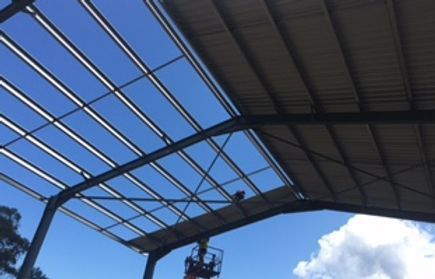 Man is Working on the Roof of a Building — Mayric Engineering in Taree, NSW