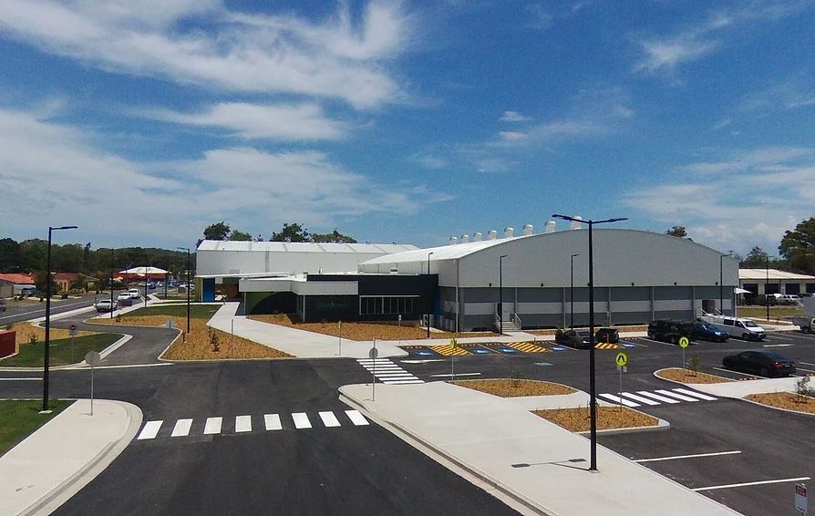 Aerial View of a Large Building With a Parking Lot in Front of It — Mayric Engineering in Taree, NSW