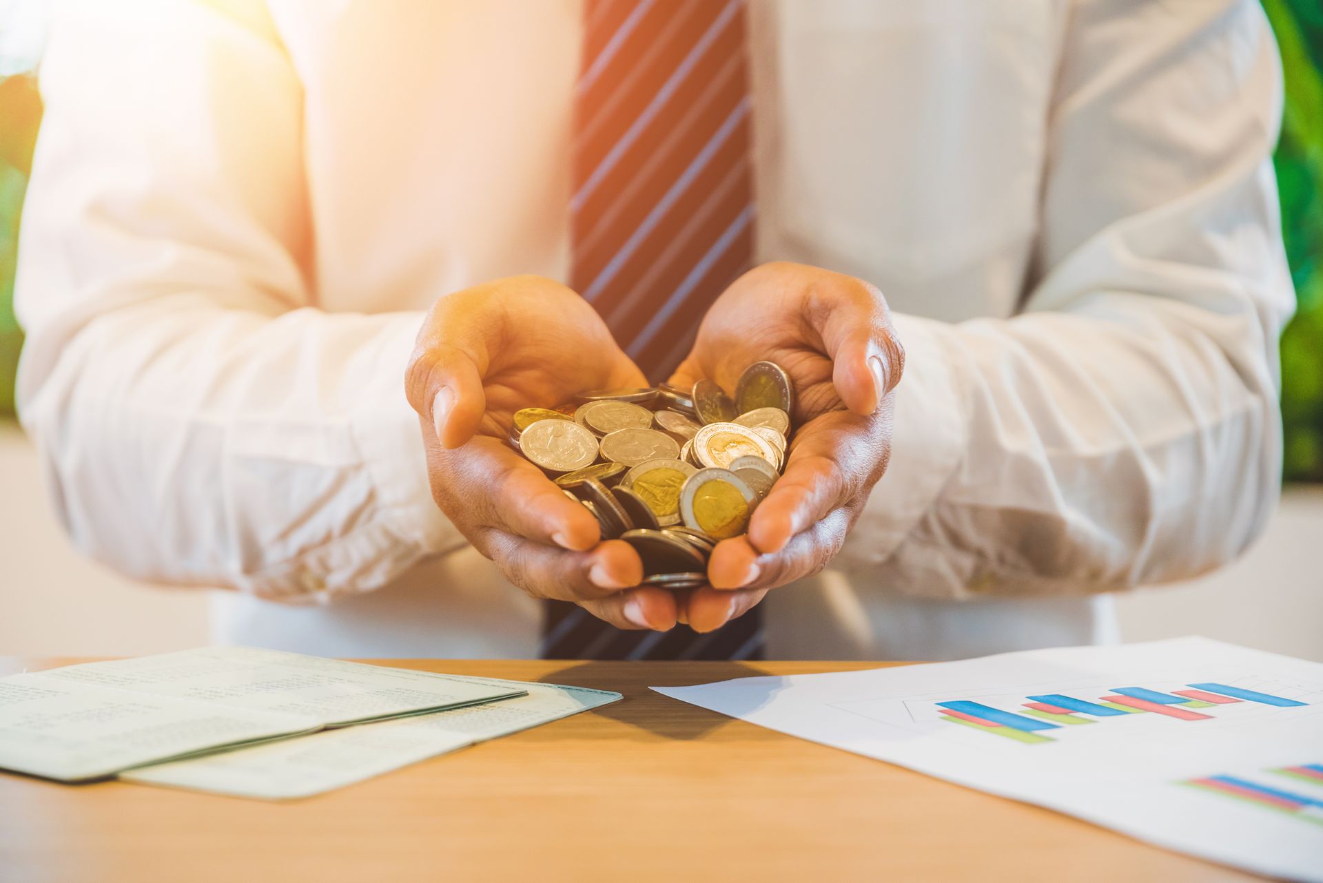A man is holding a pile of coins in his hands.