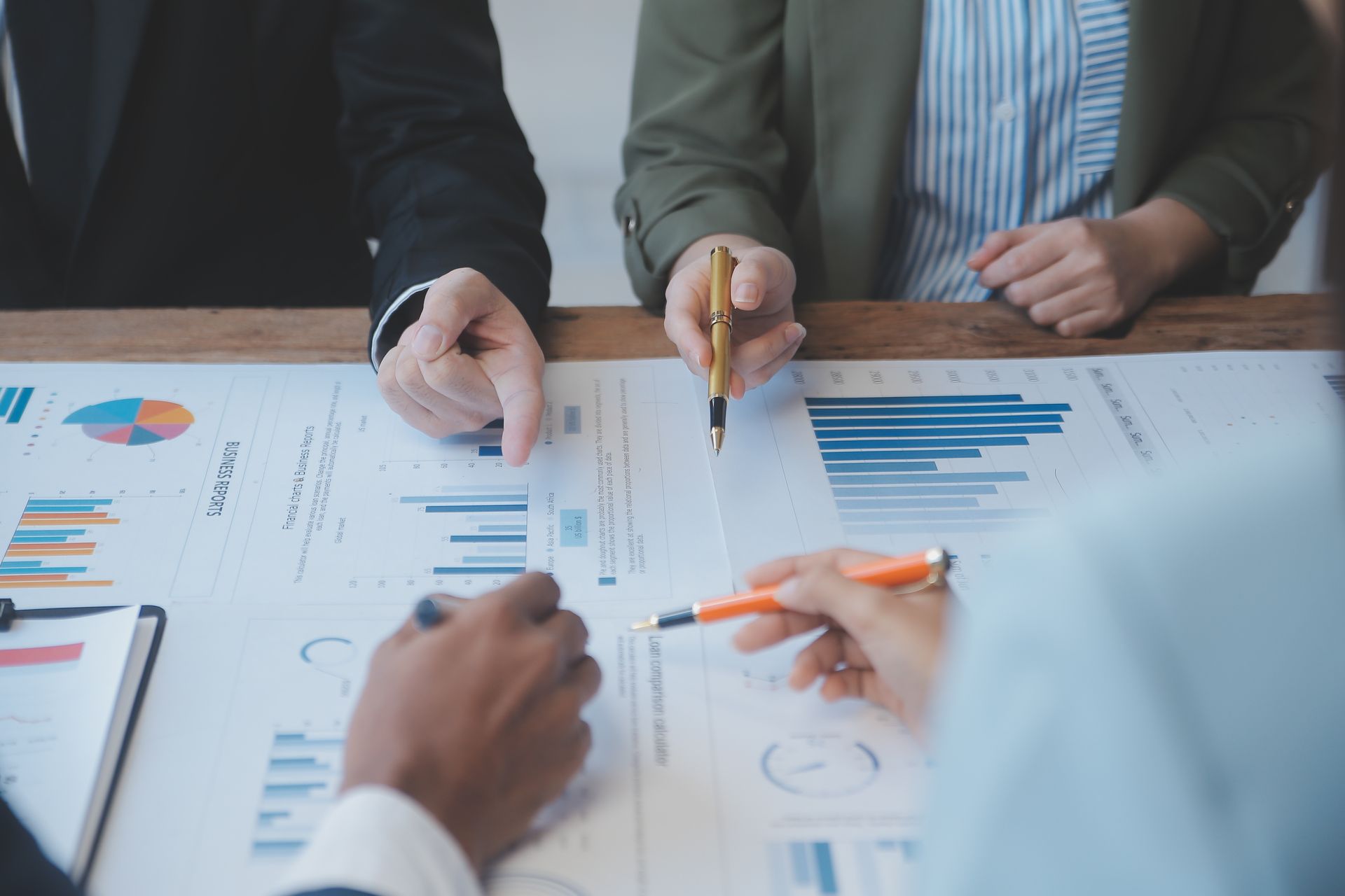 A group of people are sitting at a table looking at graphs and charts.