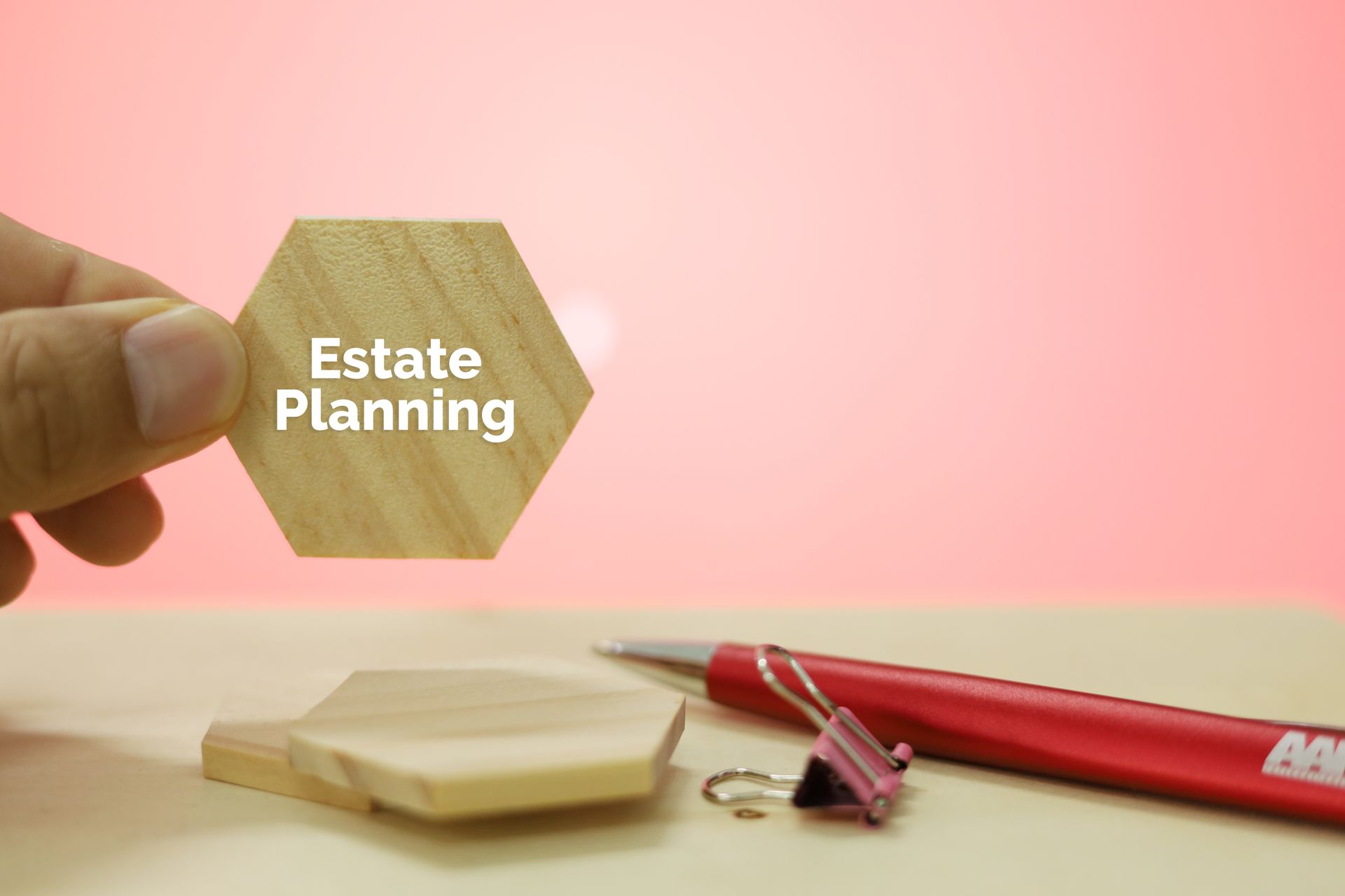 A person is holding a wooden hexagon with the words `` estate planning '' written on it.