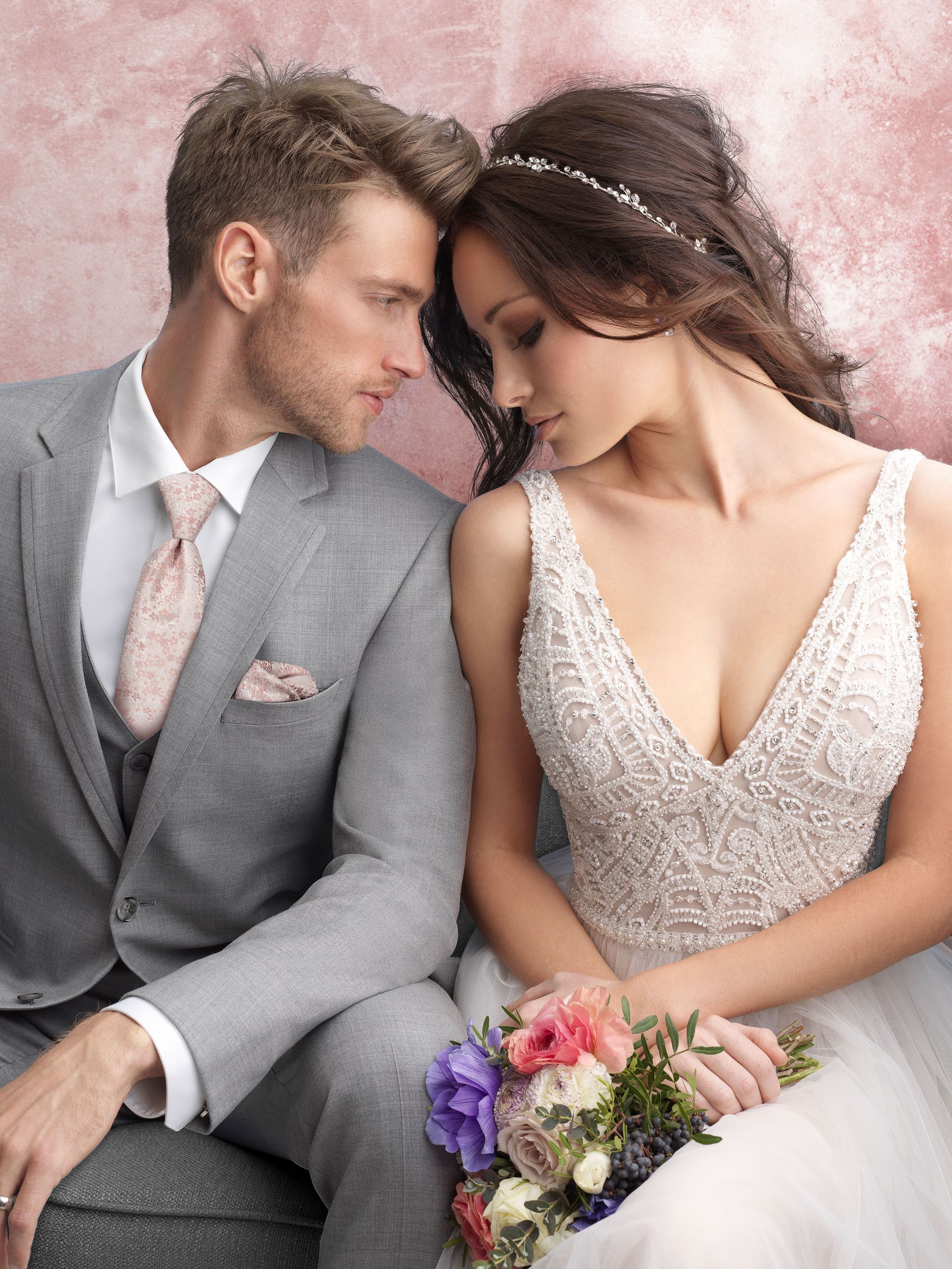 A bride and groom are sitting next to each other and looking at each other.