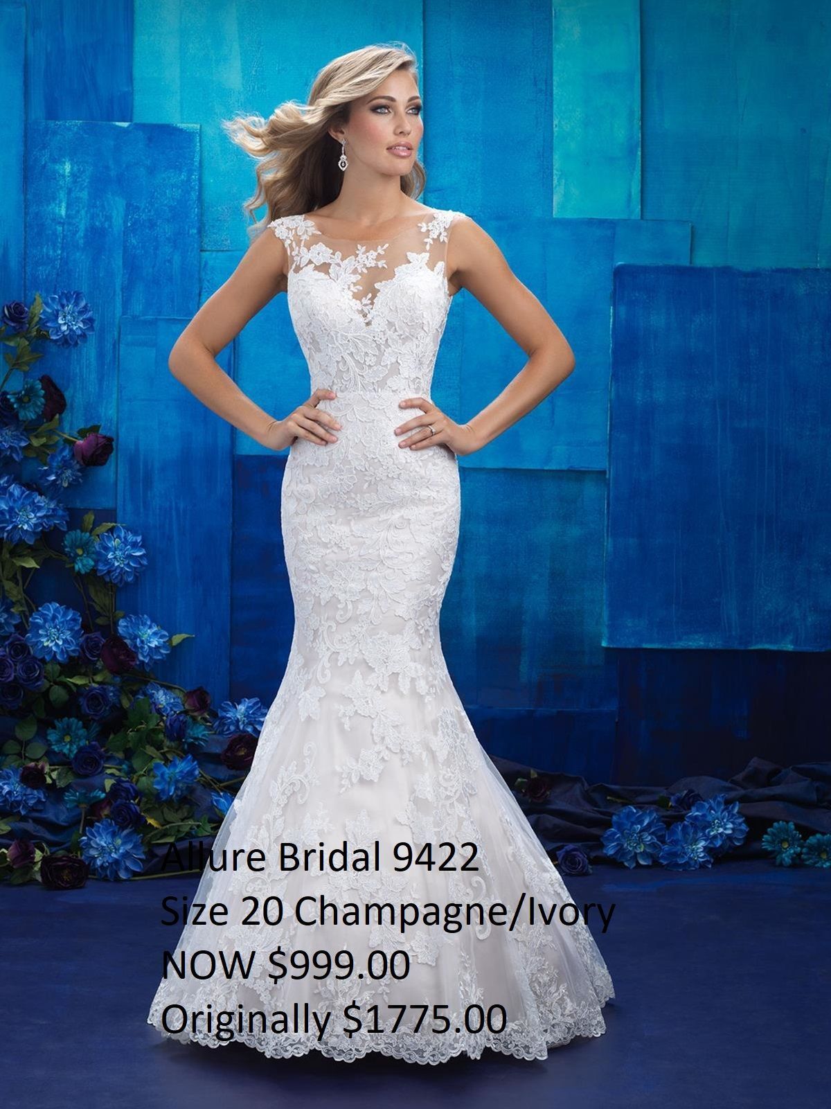 A woman in a white lace dress is standing in front of a blue wall