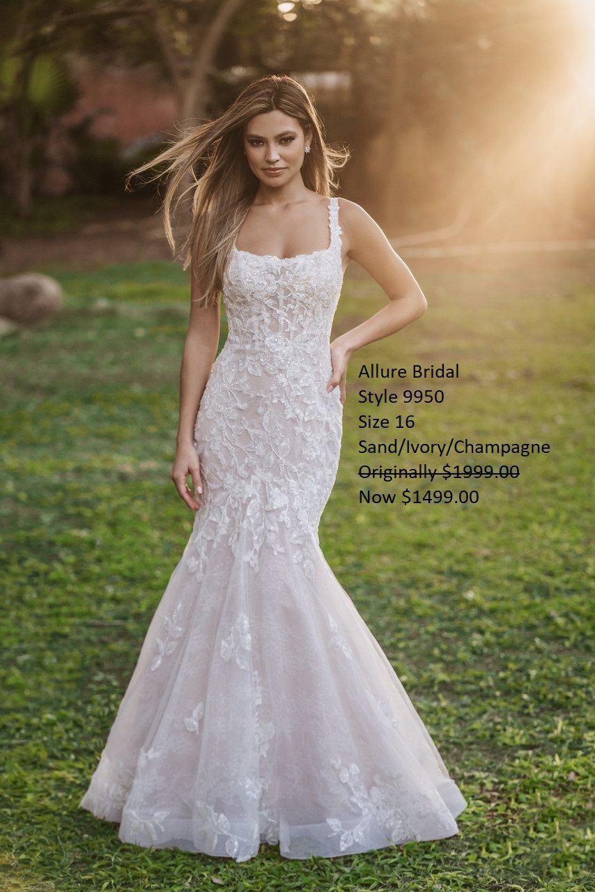 A woman in a white wedding dress is standing in the grass.