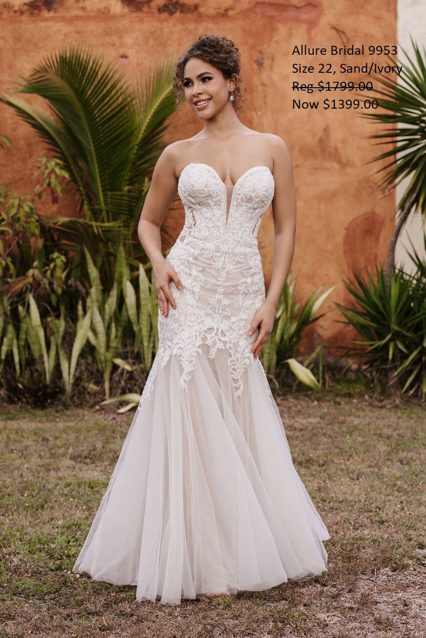 A woman in a white wedding dress is standing in a field.