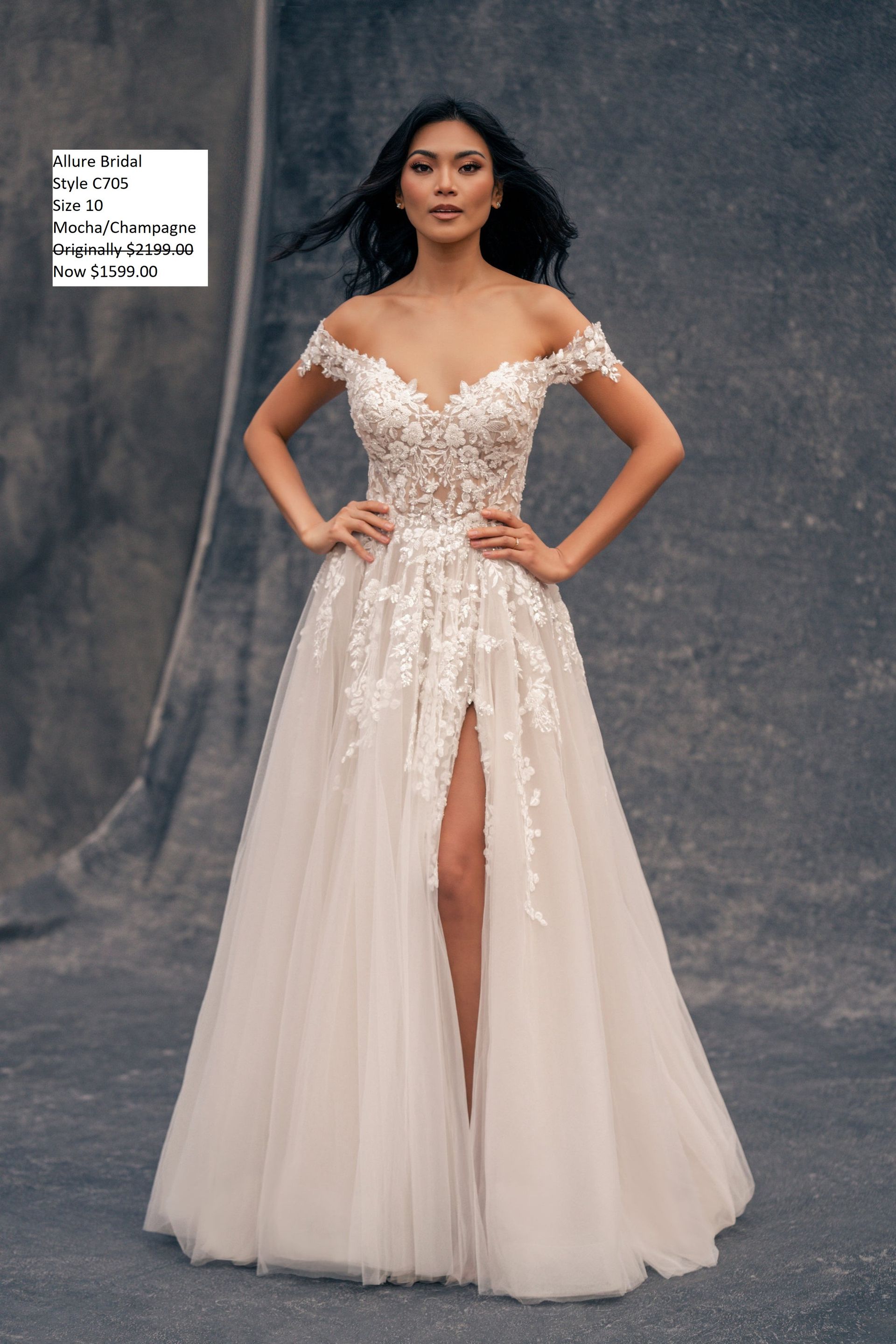 A woman is wearing a wedding dress with a high slit. Allure Couture C705