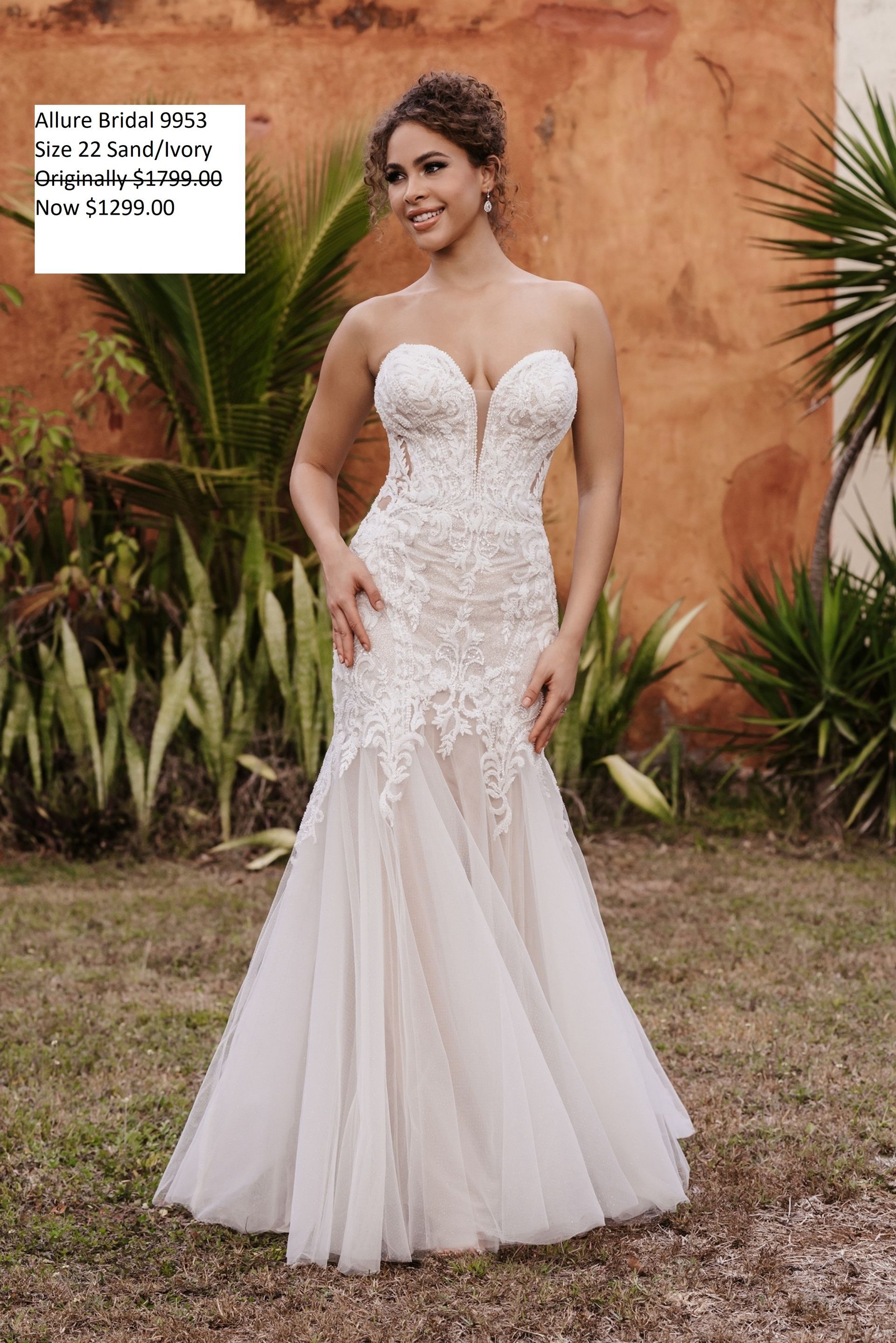 A woman in a white wedding dress is standing in a field. Allure Bridal 9953