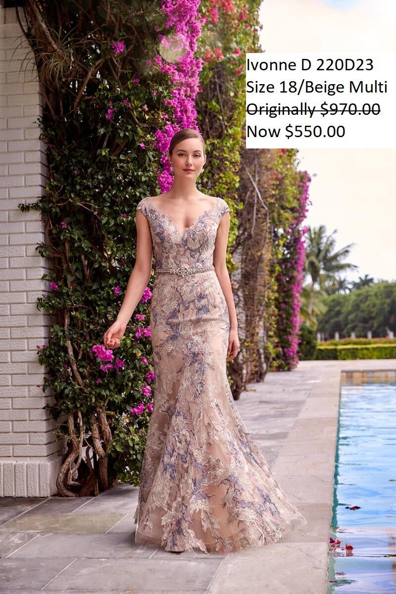 A woman in a long dress is standing next to a pool.