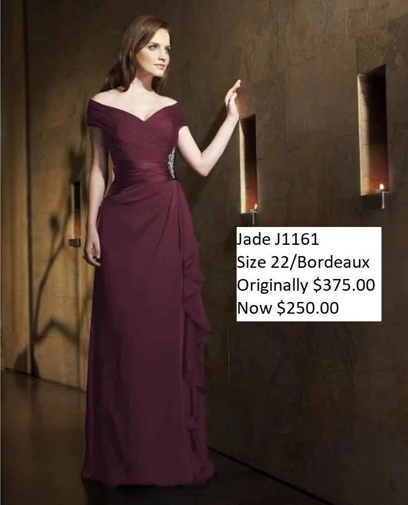 A woman is wearing a maroon off the shoulder dress