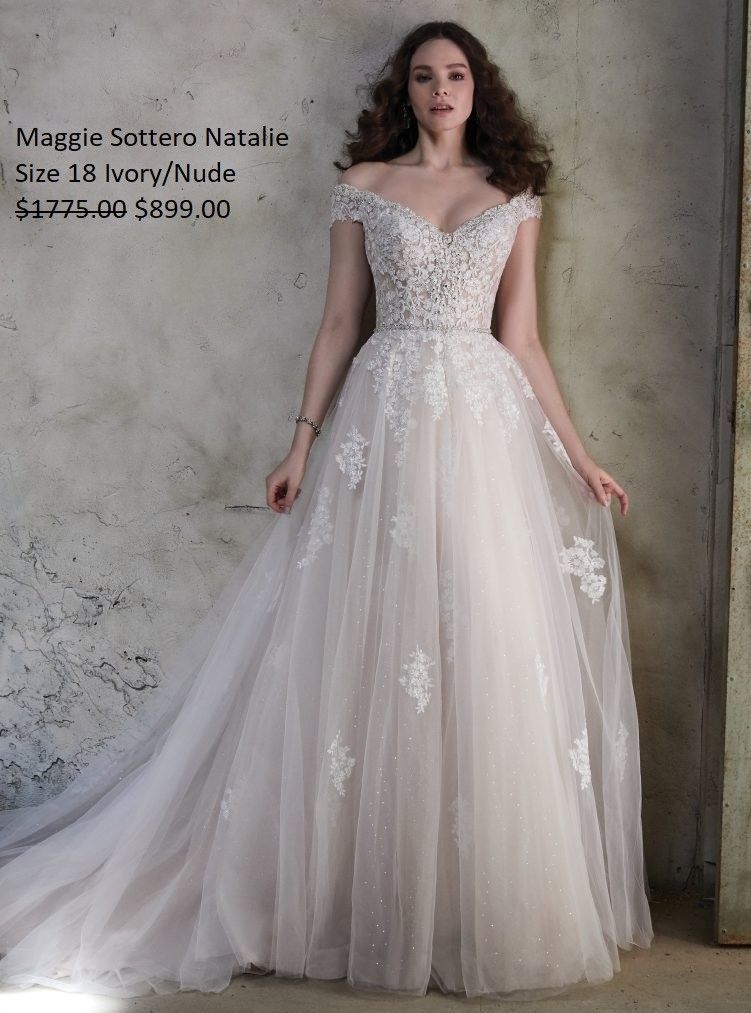 A woman in a white wedding dress is standing in front of a wall