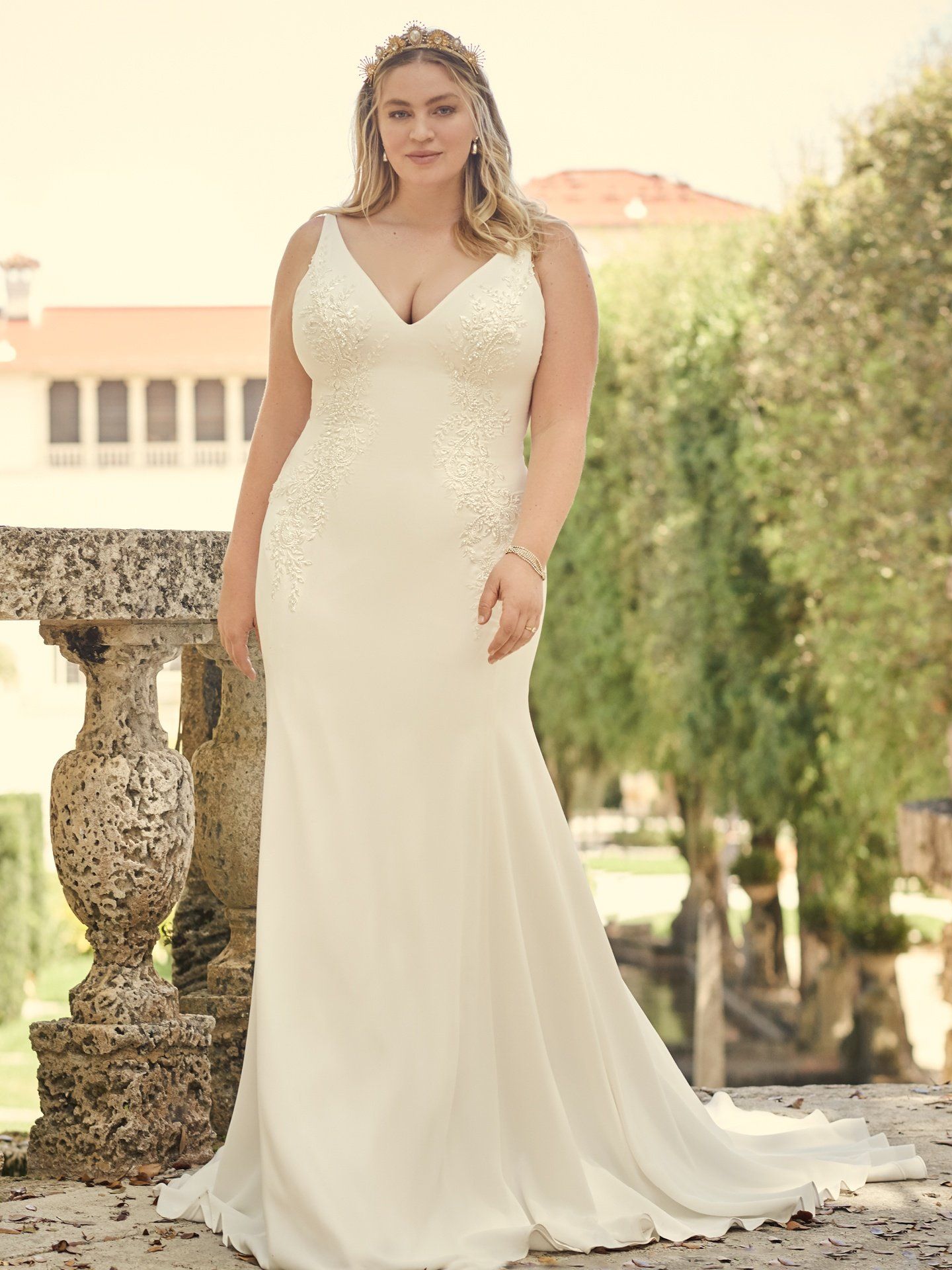 A plus size woman is wearing a white wedding dress.