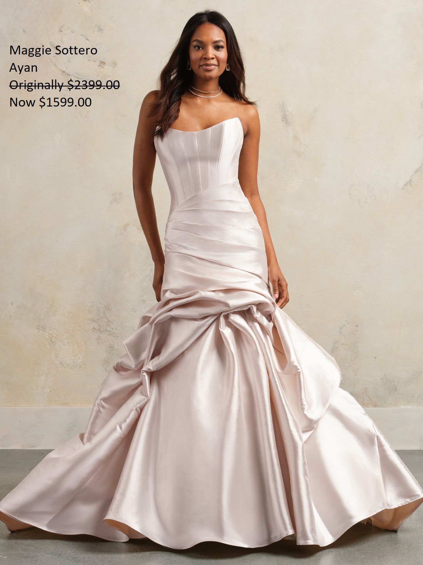 Woman in champagne-colored strapless wedding dress, on sale, in a studio setting. Maggie Sottero Ayan