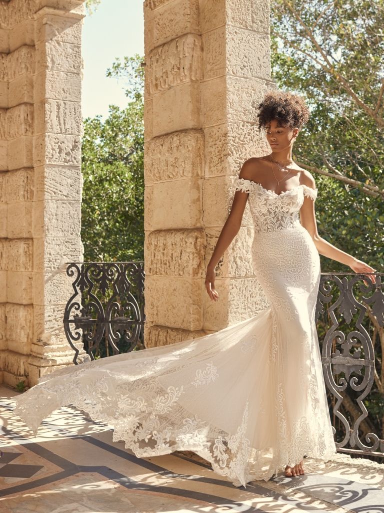 A woman in a wedding dress is standing on a balcony.