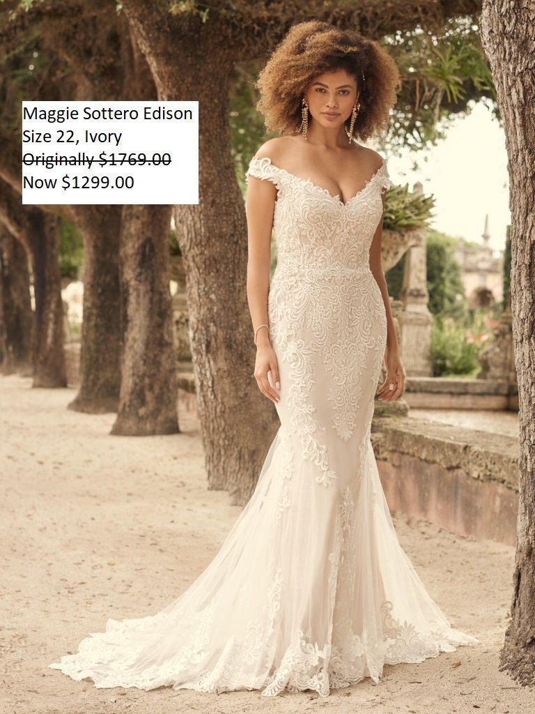 A woman in a white wedding dress is standing next to a tree.