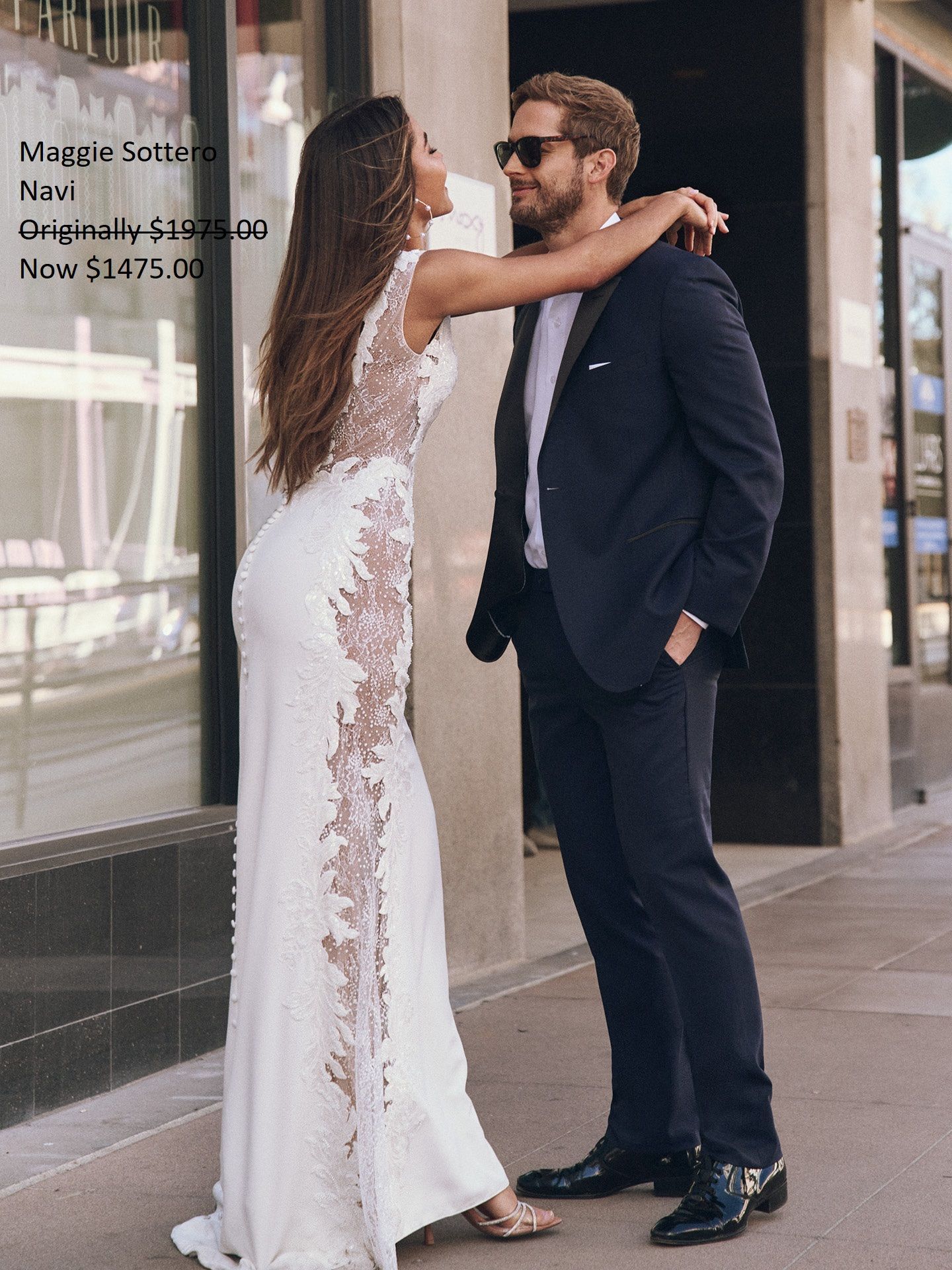 Woman in white gown hugs man in suit outdoors. Maggie Sottero Navi