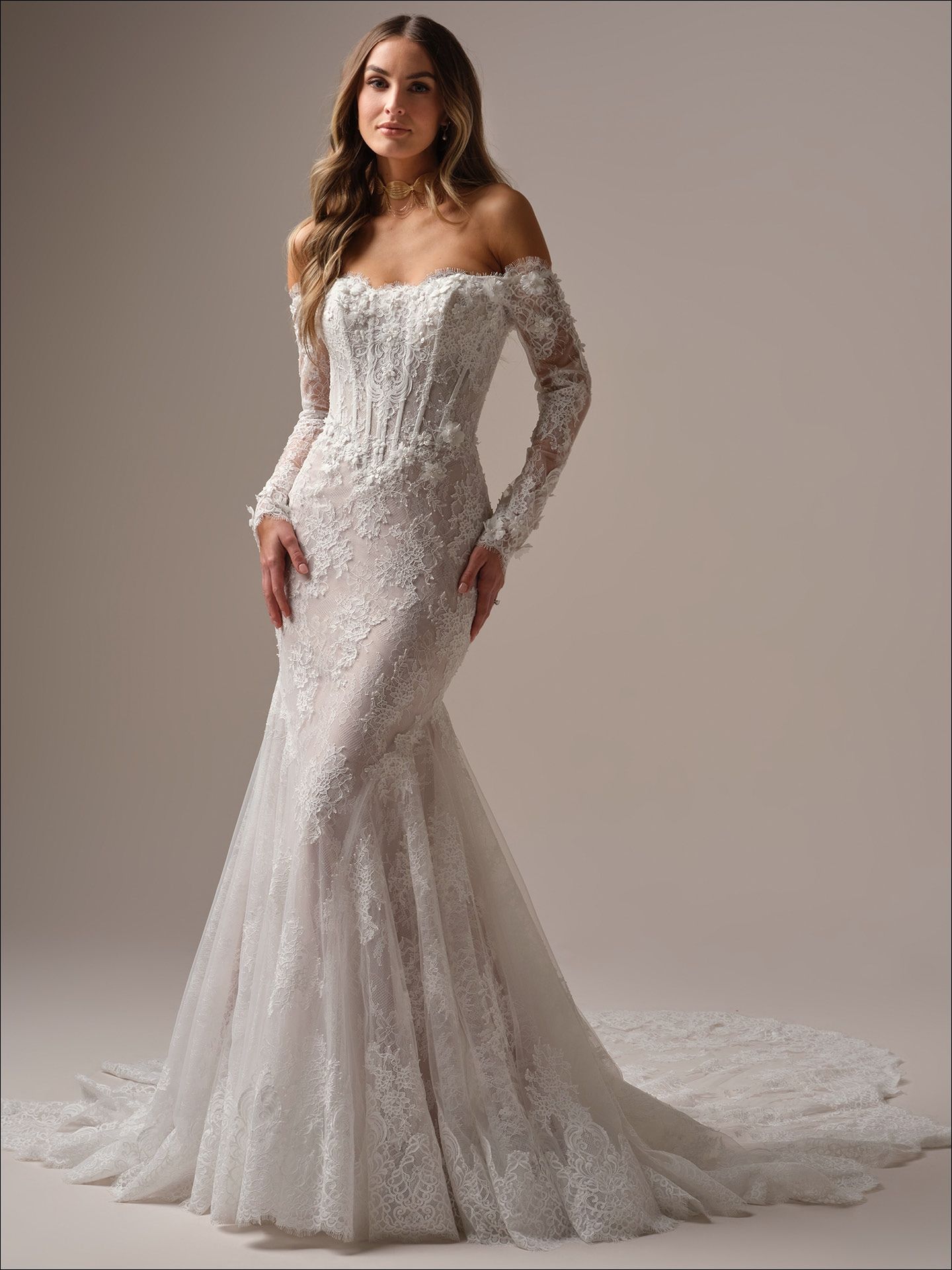 Woman in off-the-shoulder, lace wedding dress with long sleeves and a train.