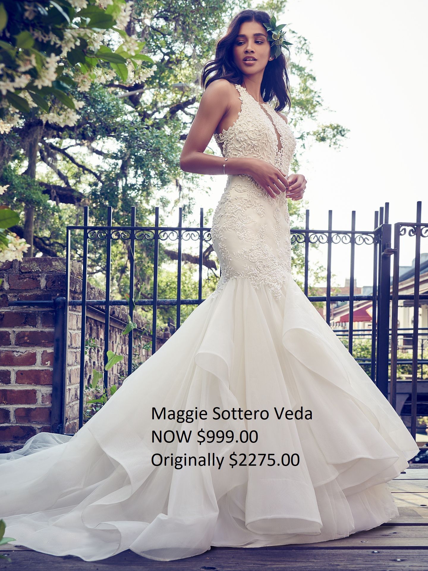 A woman in a wedding dress is standing in front of a fence.