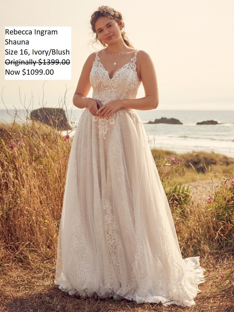 A woman in a wedding dress is standing in a field near the ocean.