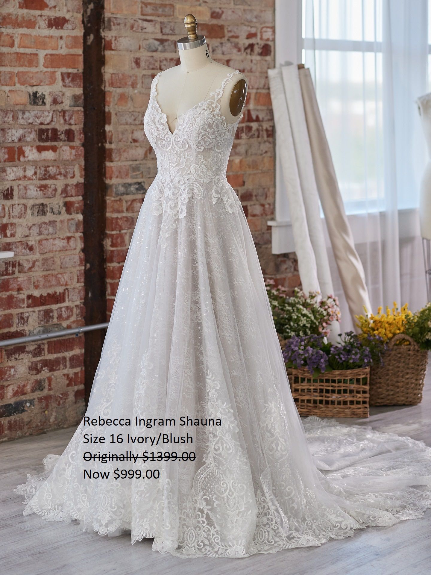 A white wedding dress is on a mannequin in front of a brick wall. Rebecca Ingram Shauna