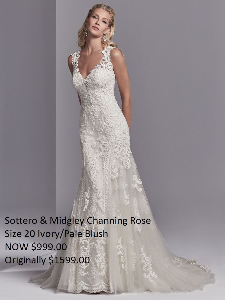 A woman is wearing a white lace wedding dress.