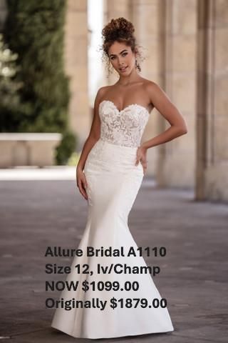 A woman in a white wedding dress is standing in front of a building. Allure Bridal A1110