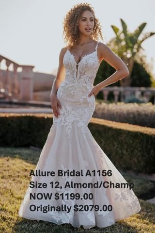 A woman in a white dress is standing in the grass. Allure Bridal A1156