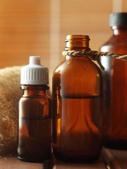 Amber glass bottles with essential oils; spa setting.