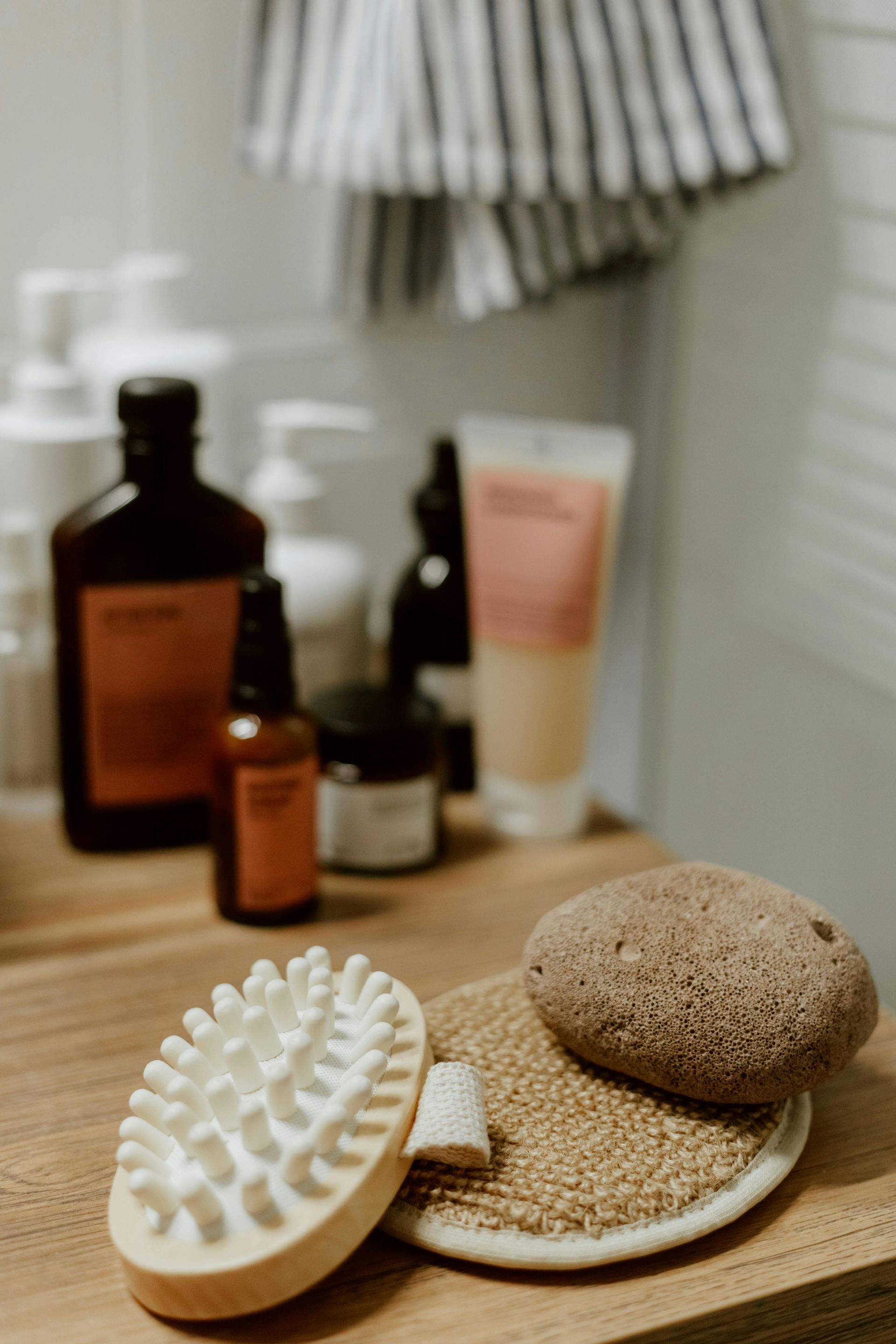 Bathroom counter with toiletries, brush, loofah, and pumice stone.