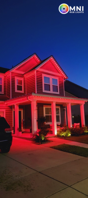 House with red lights on the roof and porch at dusk.