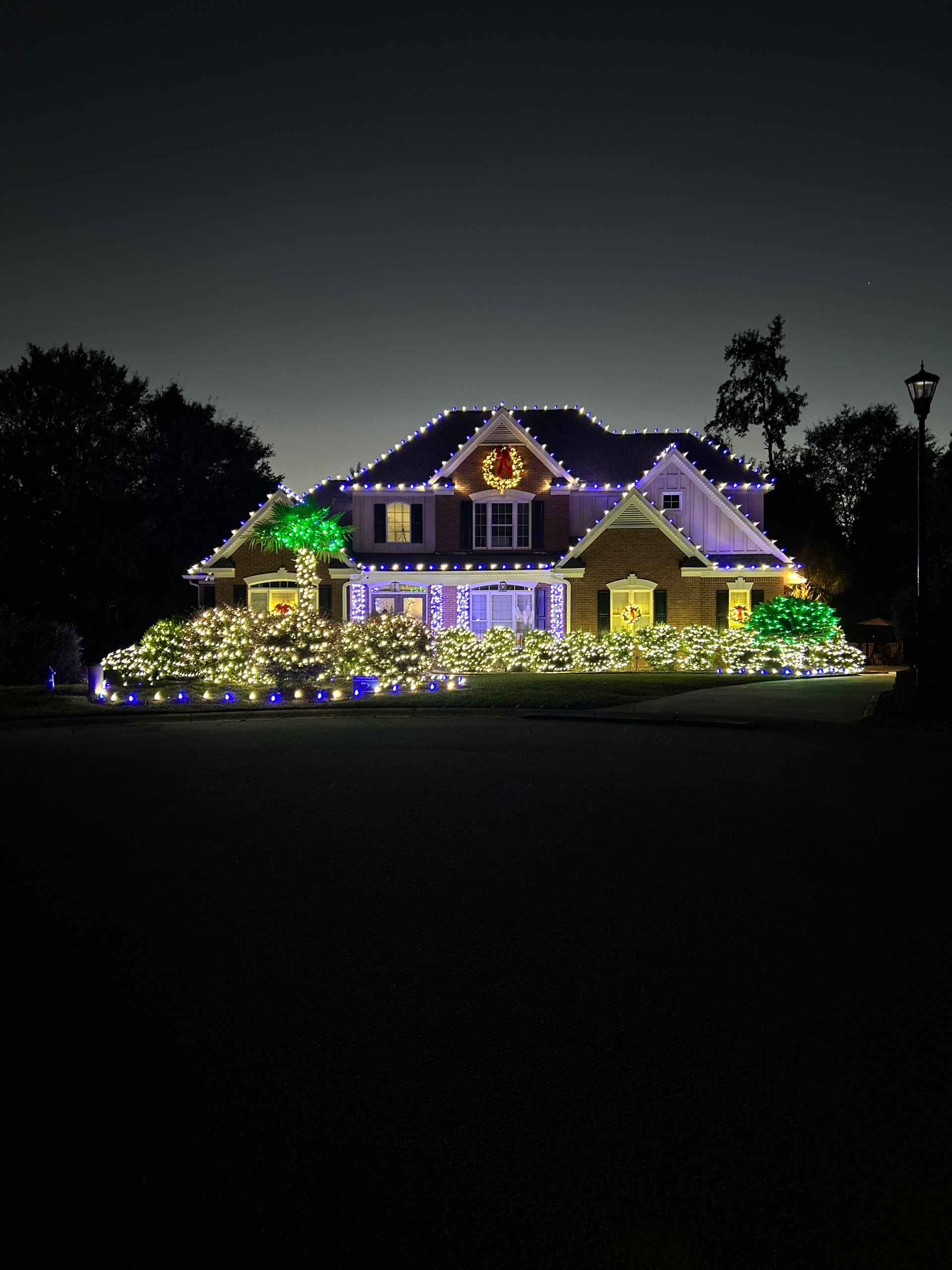House decorated with colorful Christmas lights at night.