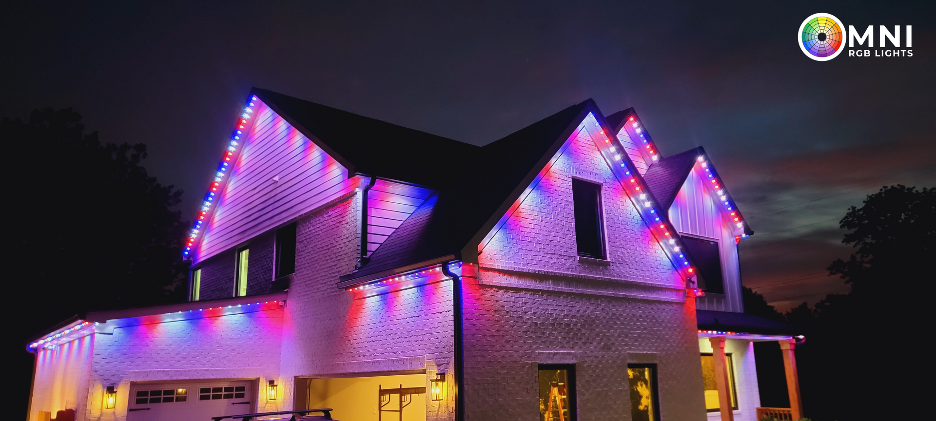 A house at night with red, white, and blue lights along the roofline and under the roof eaves.