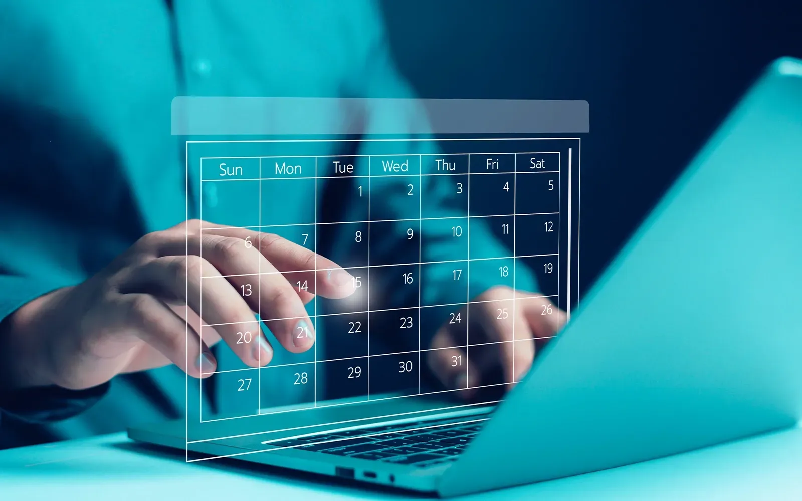 A person is typing on a laptop computer with a vir calendar on the screen