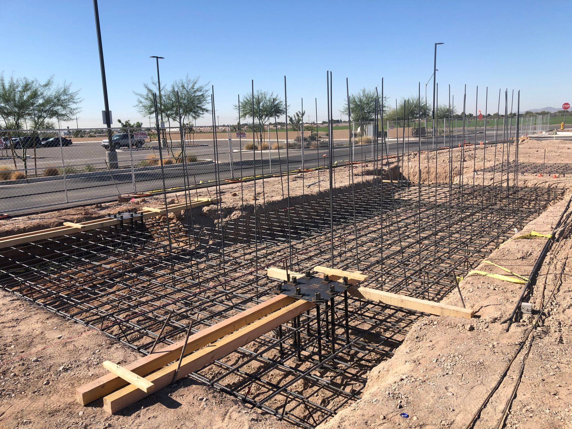 Construction site with rebar framework and wooden supports, prepared for concrete.