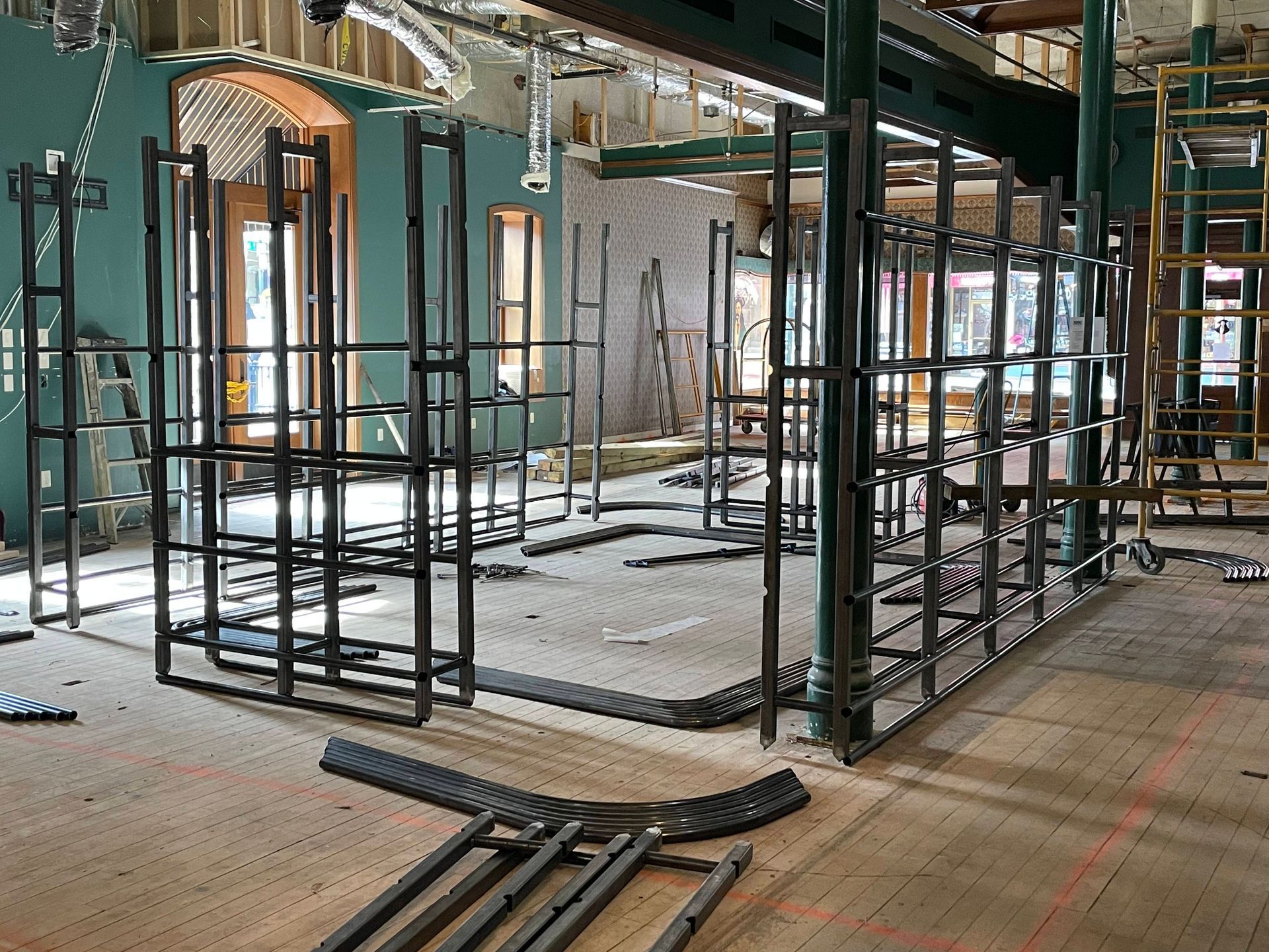 Interior construction site with black metal framing defining future walls.